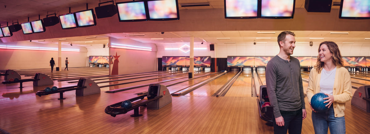 A couple laughing together on a date at a retro bowling alley